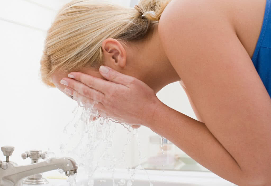 Woman washing her face with expensive face wash